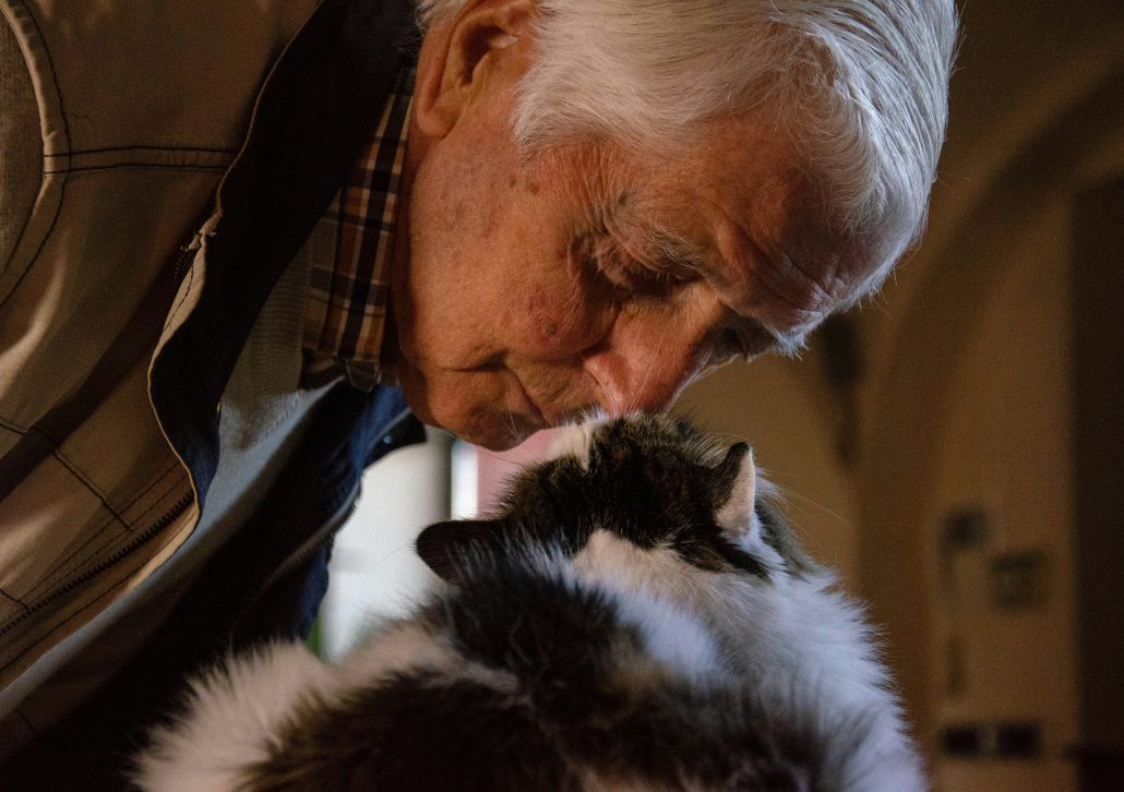 closeup of elderly man looking at his cat